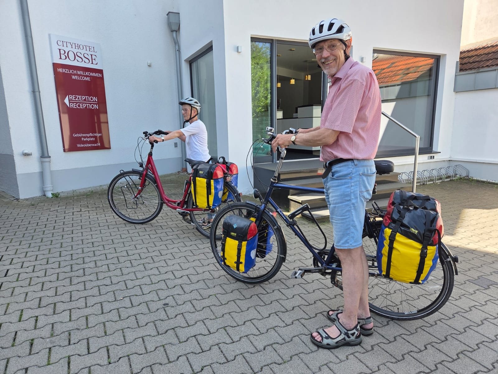 Cyclists with luggage in front of the Cityhotel Bosse